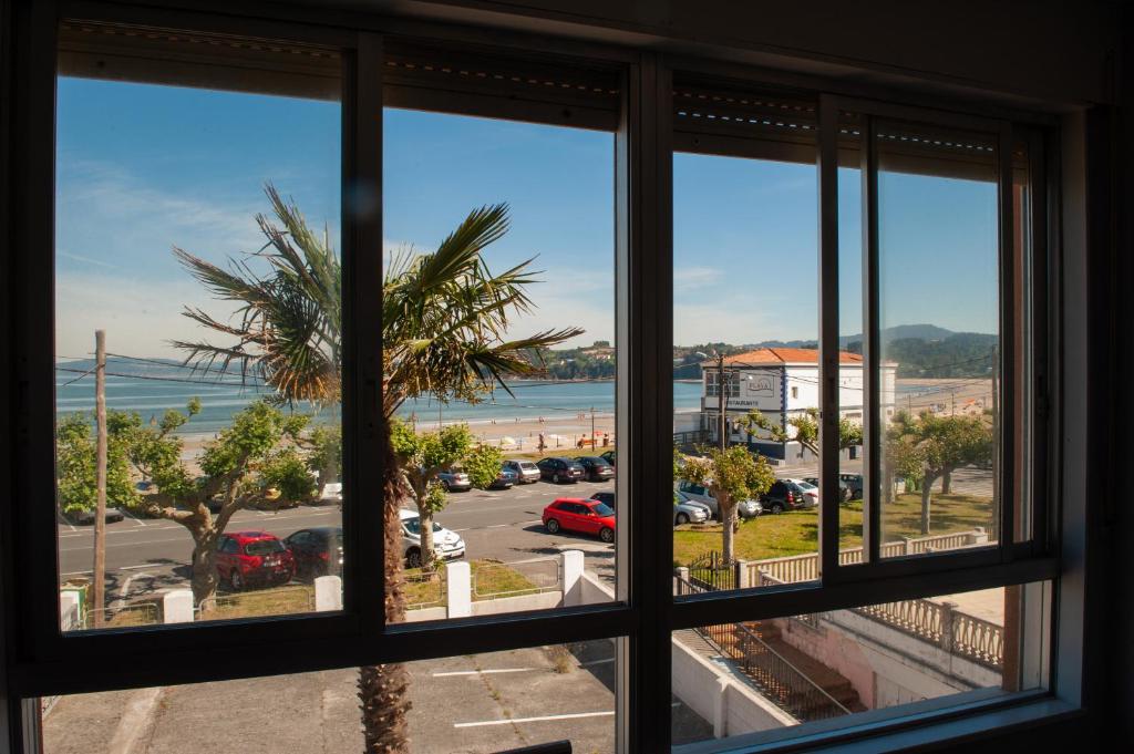 a window with a view of a parking lot at Apartamento A pie de Playa in Miño