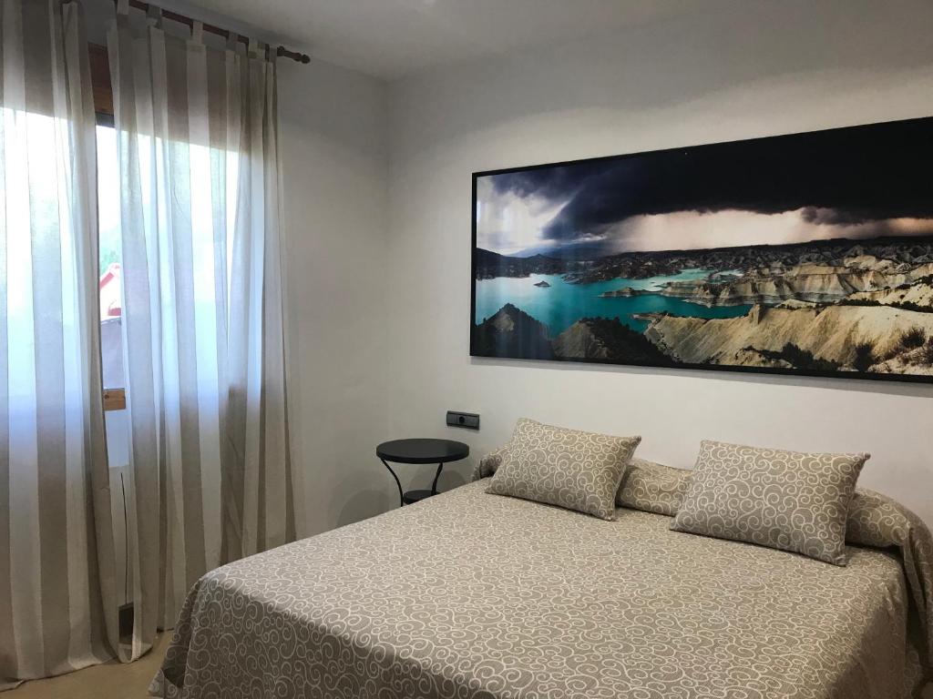 een slaapkamer met een bed en een groot schilderij aan de muur bij Apartamento Sierra Espuña in Alhama de Murcia