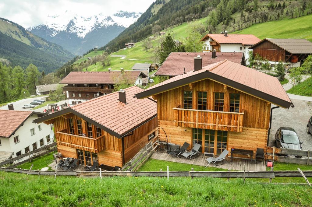 a large wooden house with mountains in the background at Auszeit Chalets in Bschlabs