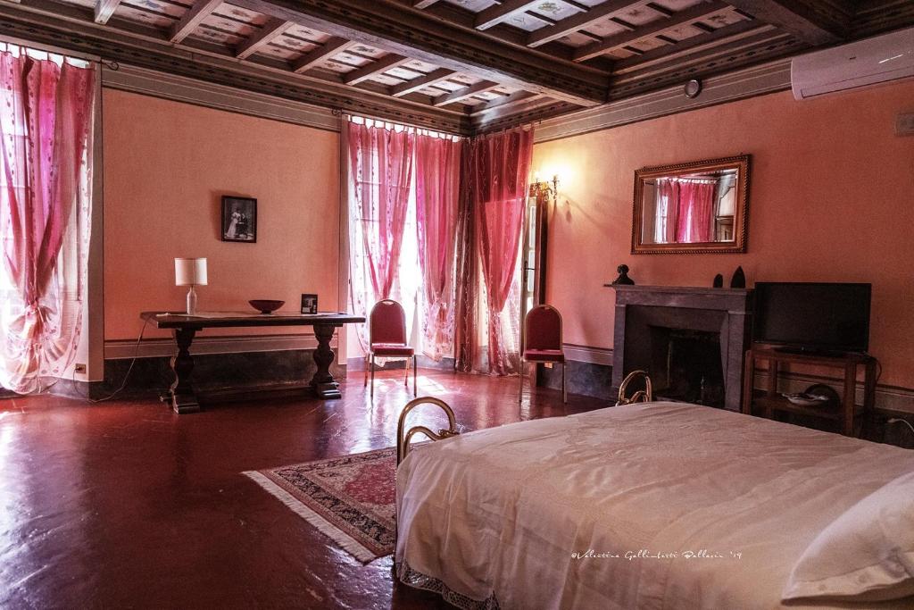 een slaapkamer met een bed, een tafel en een open haard bij Villa Cantoni in Gropello Cairoli