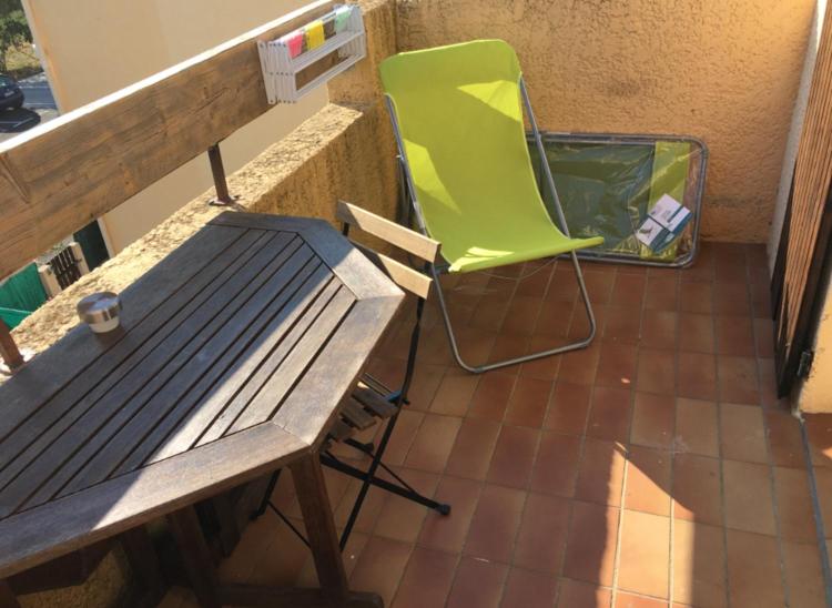 a green chair sitting next to a table and a bench at Studio rénové balcon ensoleillé et calme in La Londe-les-Maures