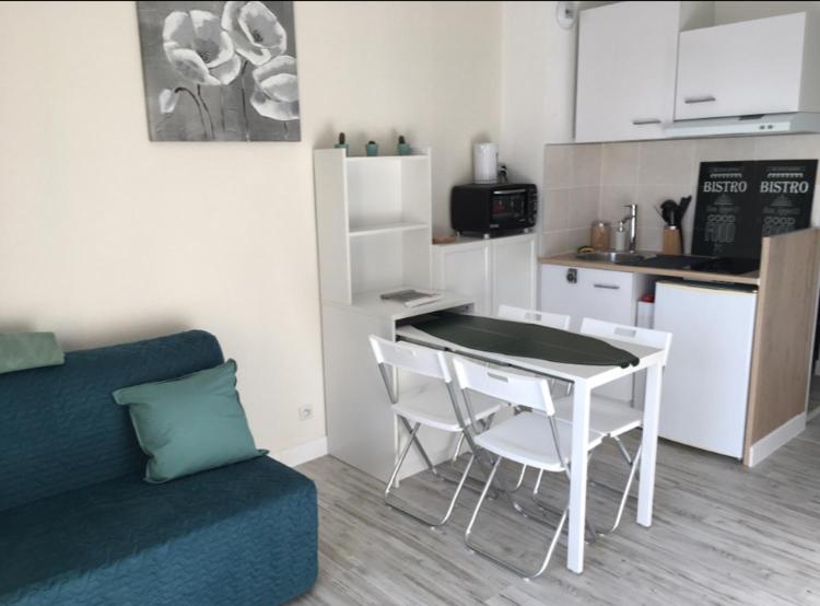 a living room with a table and a kitchen at Studio rénové balcon ensoleillé et calme in La Londe-les-Maures
