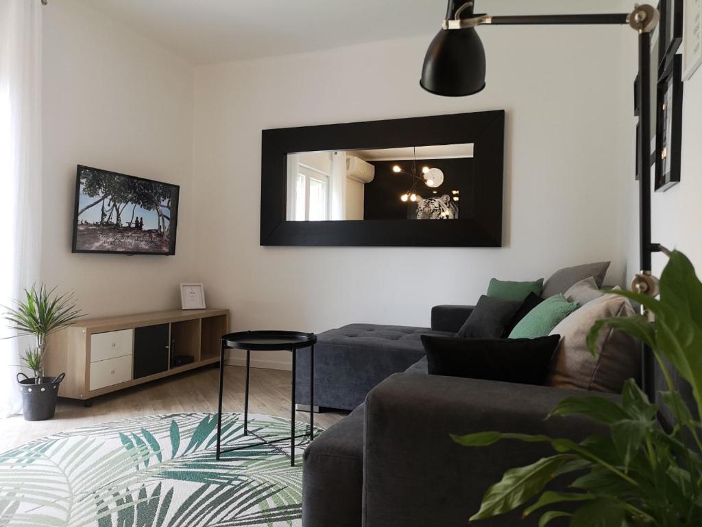 a living room with a couch and a mirror at Apartment Gervais Rijeka in Rijeka