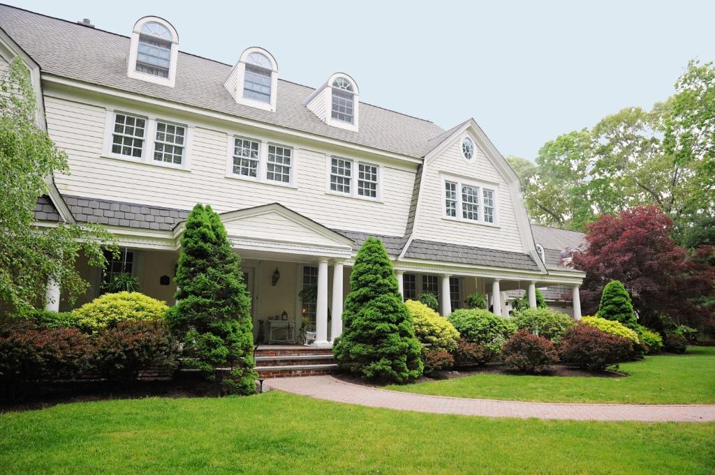 Casa blanca con porche y césped en A Walk in the Woods Bed and Breakfast en Southold