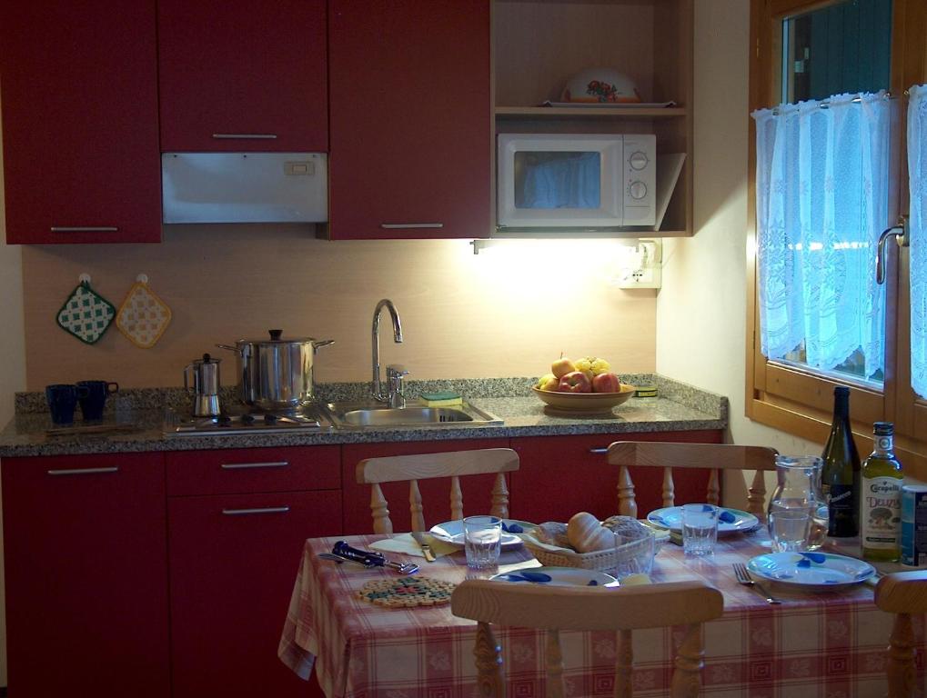 a kitchen with a table with chairs and a sink at Chalet Presanella in Temù