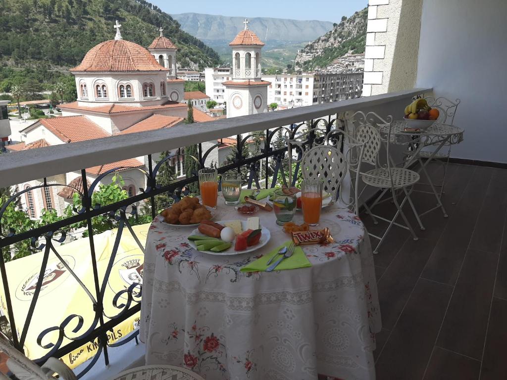 een tafel met een bord eten op een balkon bij HOTEL VILA TWIX in Berat