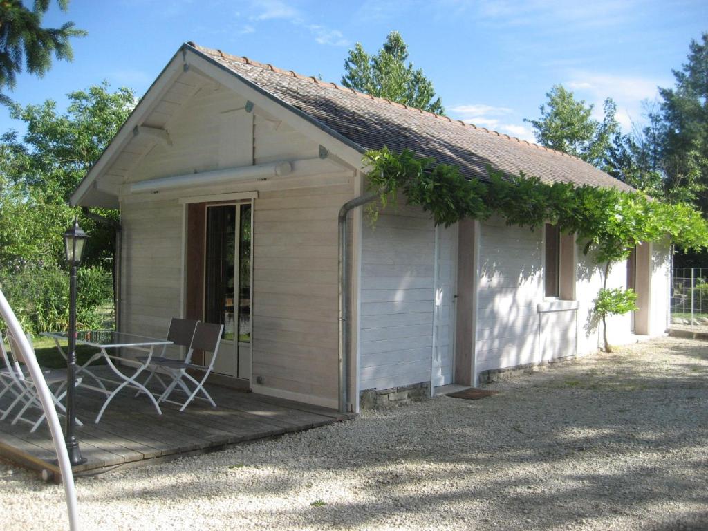un petit hangar blanc avec une table et des chaises dans l'établissement Au Paradis des oiseaux, à Rumilly-lès-Vaudes