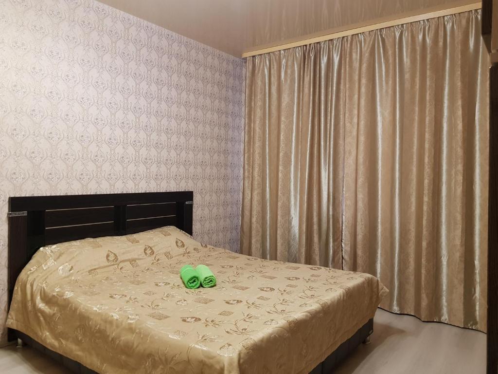 sypialnia z łóżkiem z zielonym przedmiotem w obiekcie Улучшенные апартаменты на Ауре w mieście Surgut
