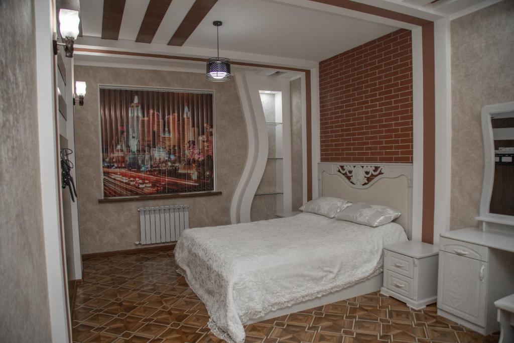 Un dormitorio con una cama y una pared de ladrillo. en Favorite apartment, en Samarkand