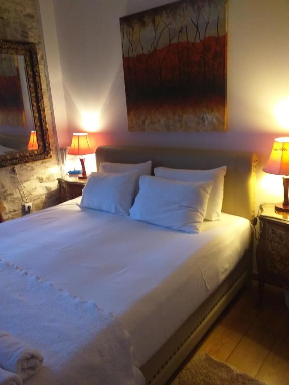 a bedroom with a large white bed with two lamps at Boutique Hotel Tsopela in Skiathos Town