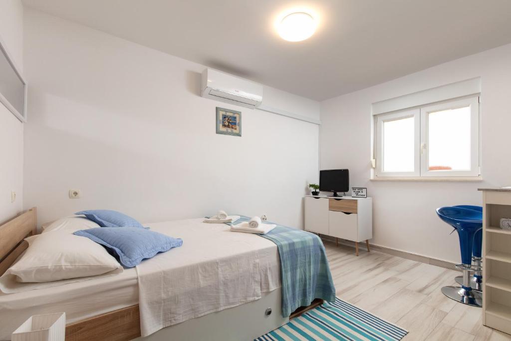 ein weißes Schlafzimmer mit einem Bett und einem Schreibtisch in der Unterkunft Le Ines in Split