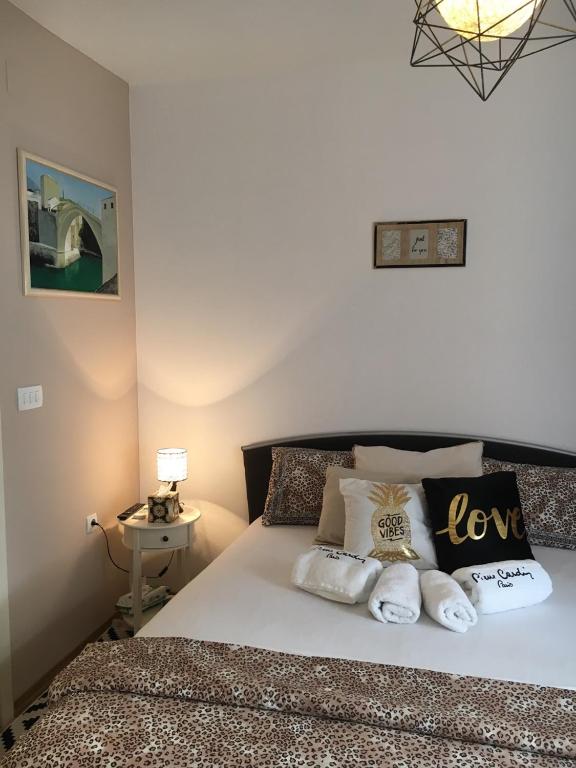 una camera da letto con un letto grande con cuscini sopra di Apartment Smile a Mostar