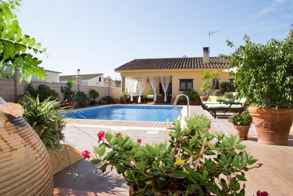 een huis met een zwembad en een aantal planten bij Villa Ca La Vicen in Deltebre
