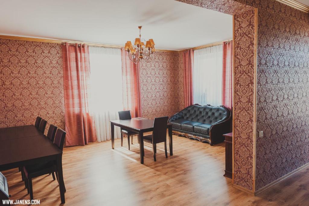 ein Wohnzimmer mit einem Sofa und einem Tisch in der Unterkunft Family Hotel in Daugavpils