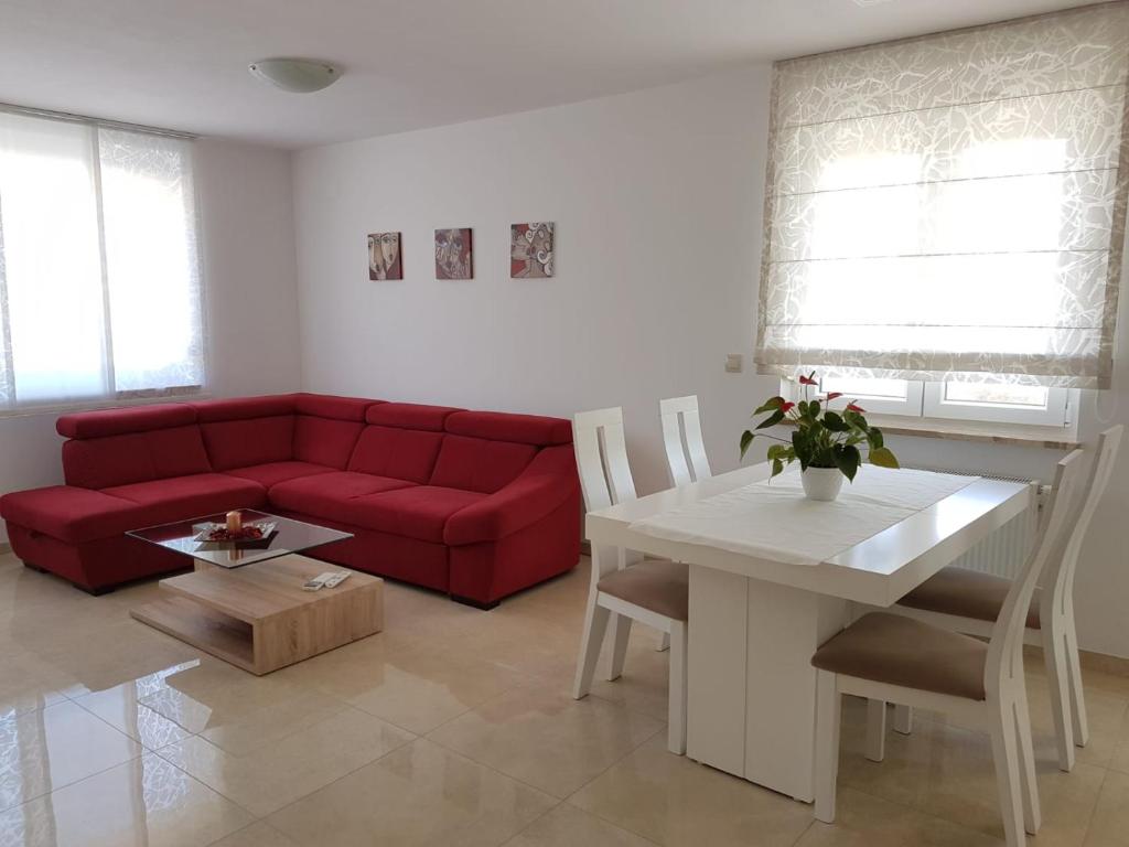 salon z czerwoną kanapą i stołem w obiekcie Apartman Ivana w mieście Porat