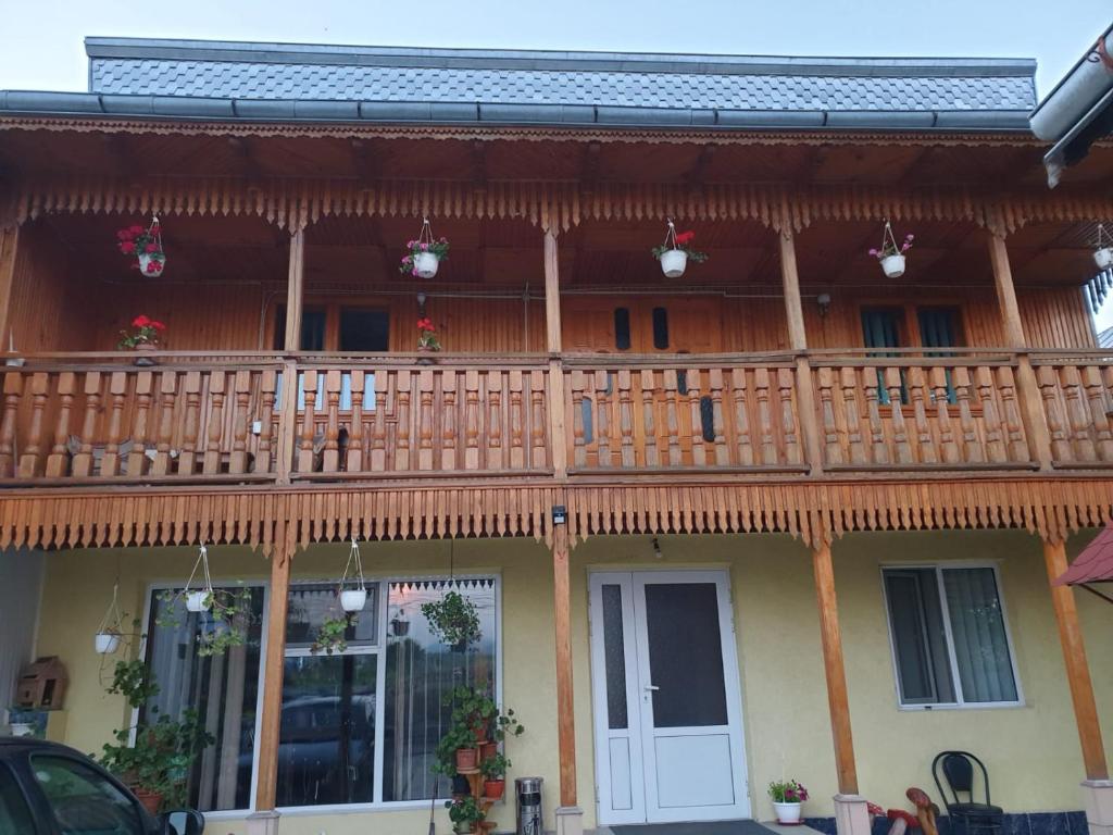 una casa con una terraza de madera encima en Pensiunea Casa Ana en Agapia