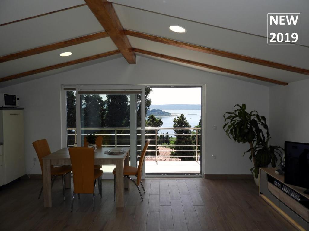 a dining room with a table and chairs and a large window at Red Rose Apartment in Portorož