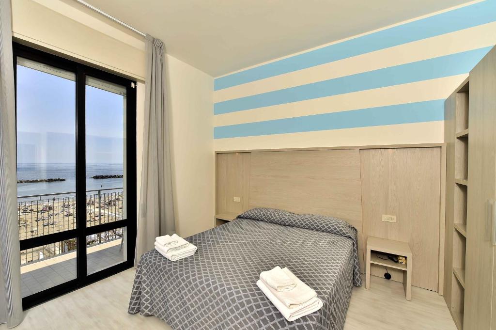 a bedroom with a bed and a large window at Hotel Admiral in Bellaria-Igea Marina