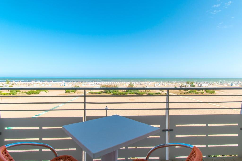 a table and chairs on a balcony with the beach at Hotel Continental in Caorle