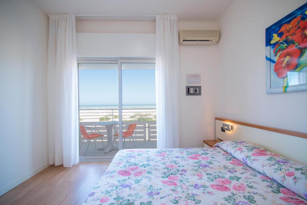 a bedroom with a bed and a view of the ocean at Hotel Continental in Caorle
