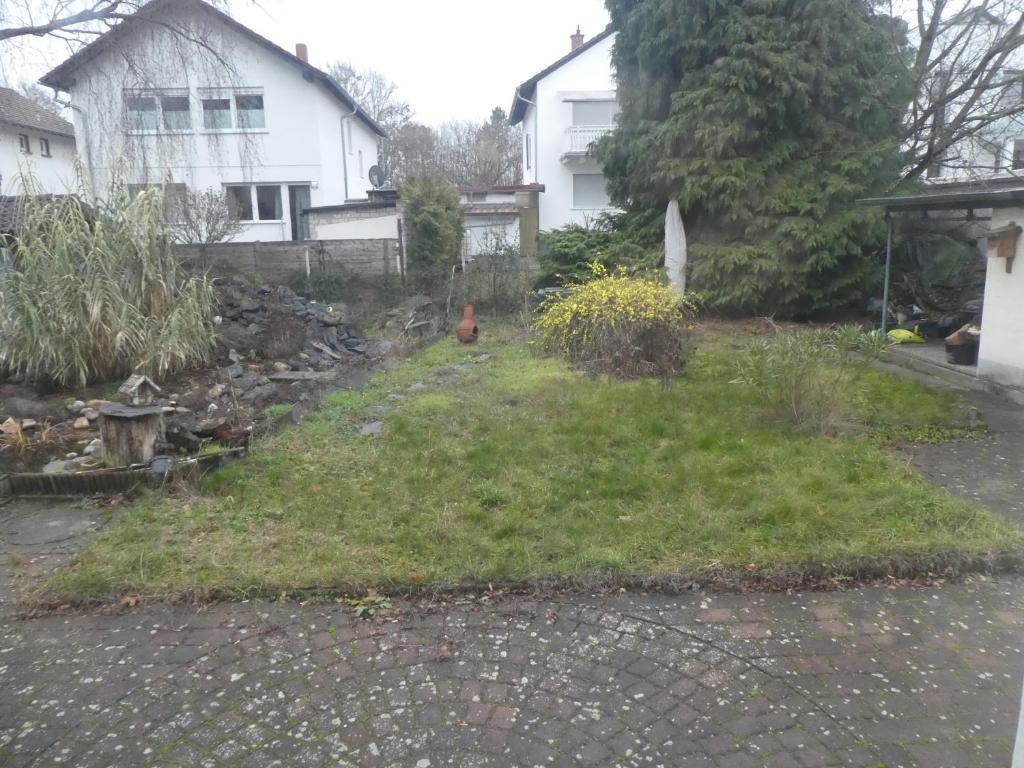 een tuin voor een wit huis bij Ferienwohnung Mainz-Weisenau in Mainz