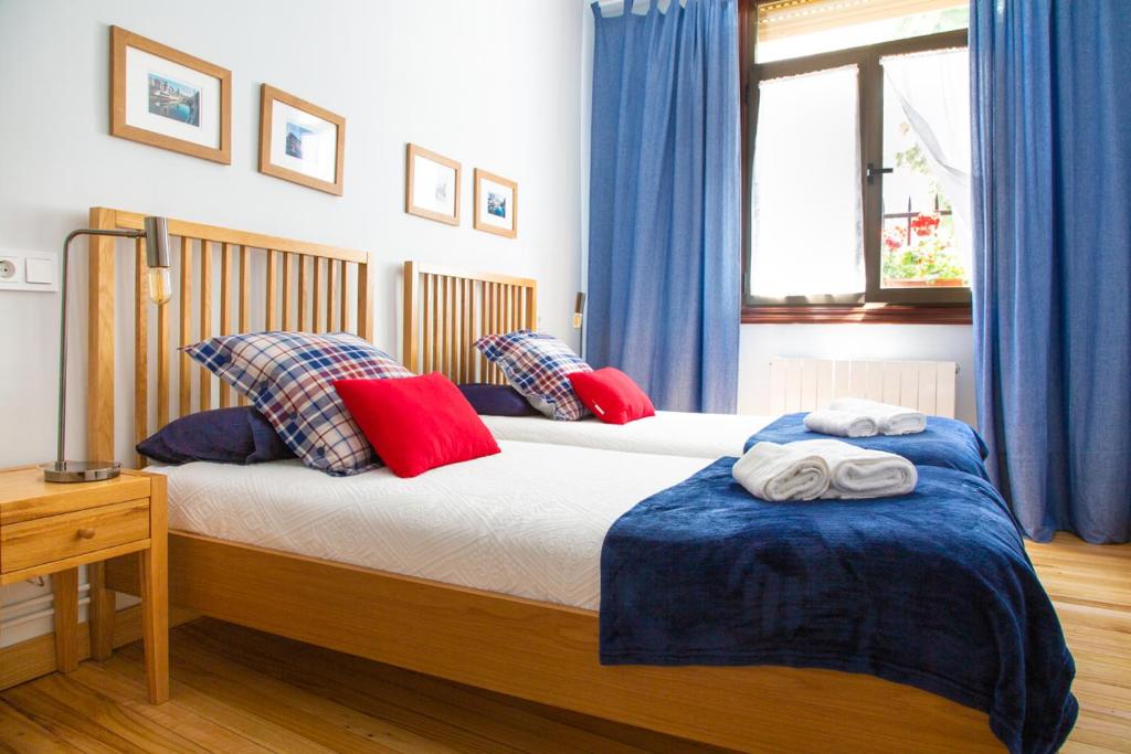 ビルバオにあるAresti Old Town by Bilbao Livingのベッドルーム1室(青いカーテン付きのベッド2台付)