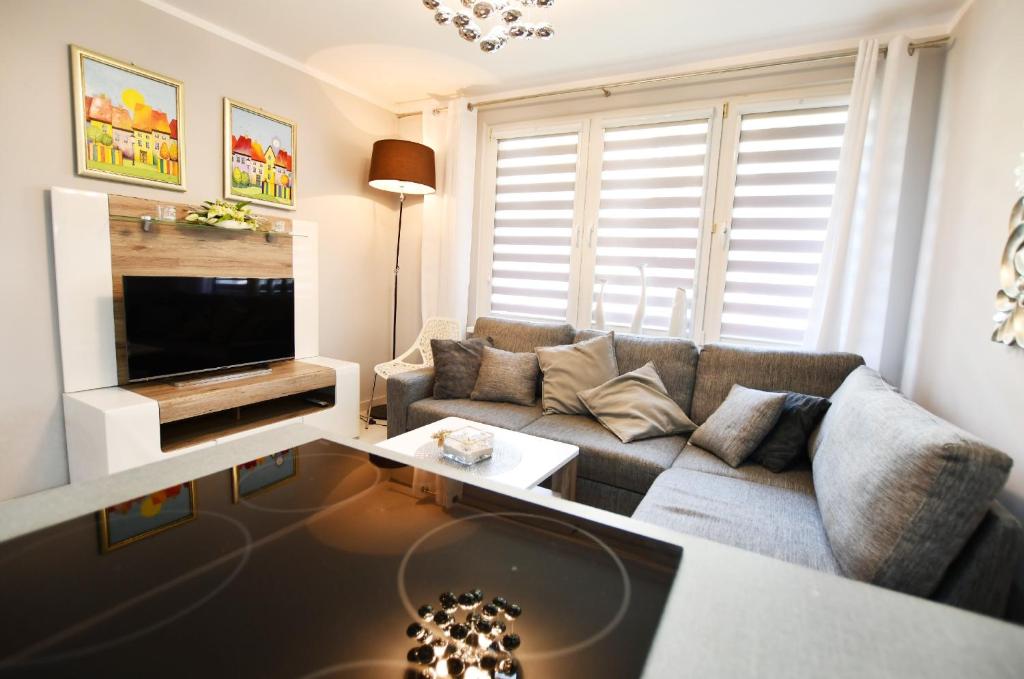 a living room with a couch and a tv at Apartament Dworcowa in Kołobrzeg