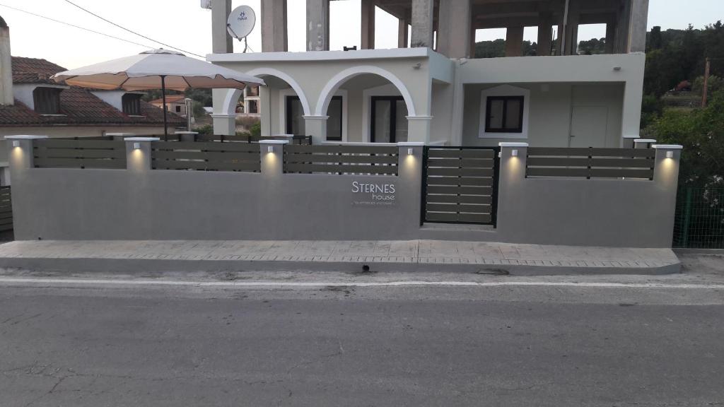 una casa blanca con una puerta y una sombrilla en STERNES house, en Agios Leon