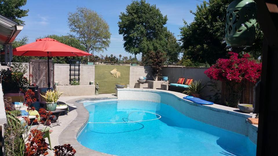 a swimming pool in a yard with an umbrella at Cool Casual Living A/C,Non-Smoking, 25+ and over in Lakewood