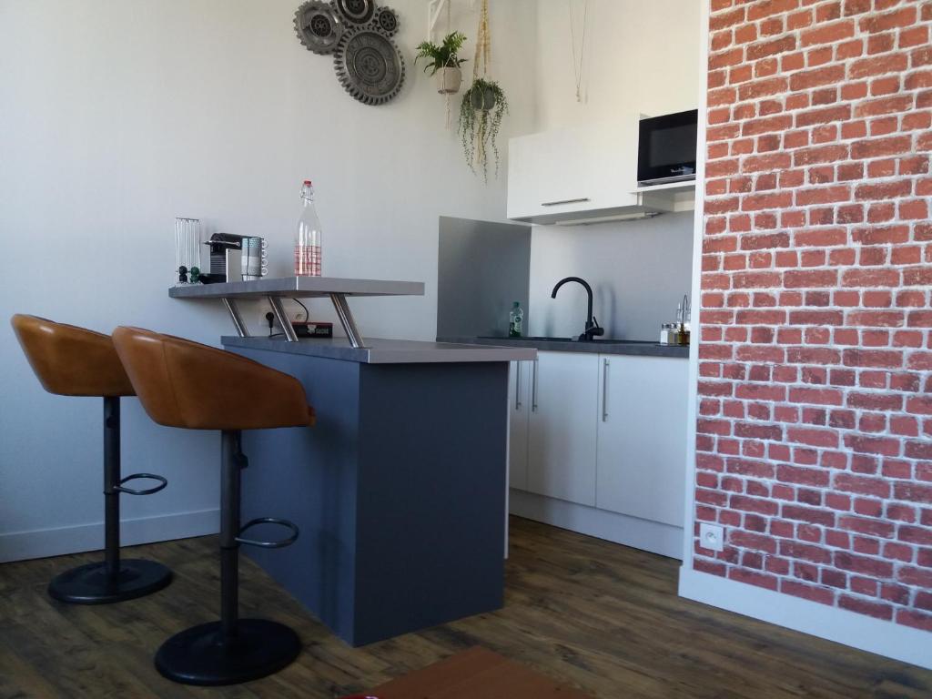 a kitchen with a blue counter and a brick wall at L' ALBATROS vue sur le port in Fécamp