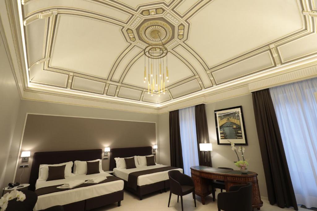 卡塔尼亚ETNEA STYLE CATANIA LUXURY ROOMS的酒店客房设有两张床和格子天花板