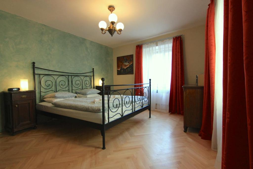 een slaapkamer met een bed en een kroonluchter bij Mala Strana apartment 1 in Praag