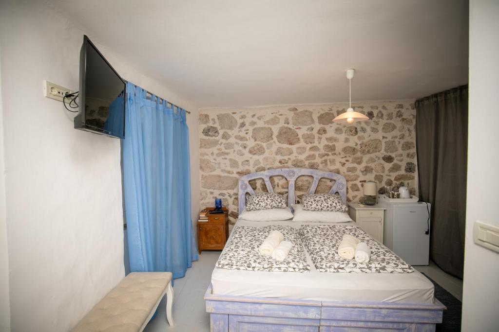 een slaapkamer met een bed en een tv. bij Rooms Epidaurus in Dubrovnik