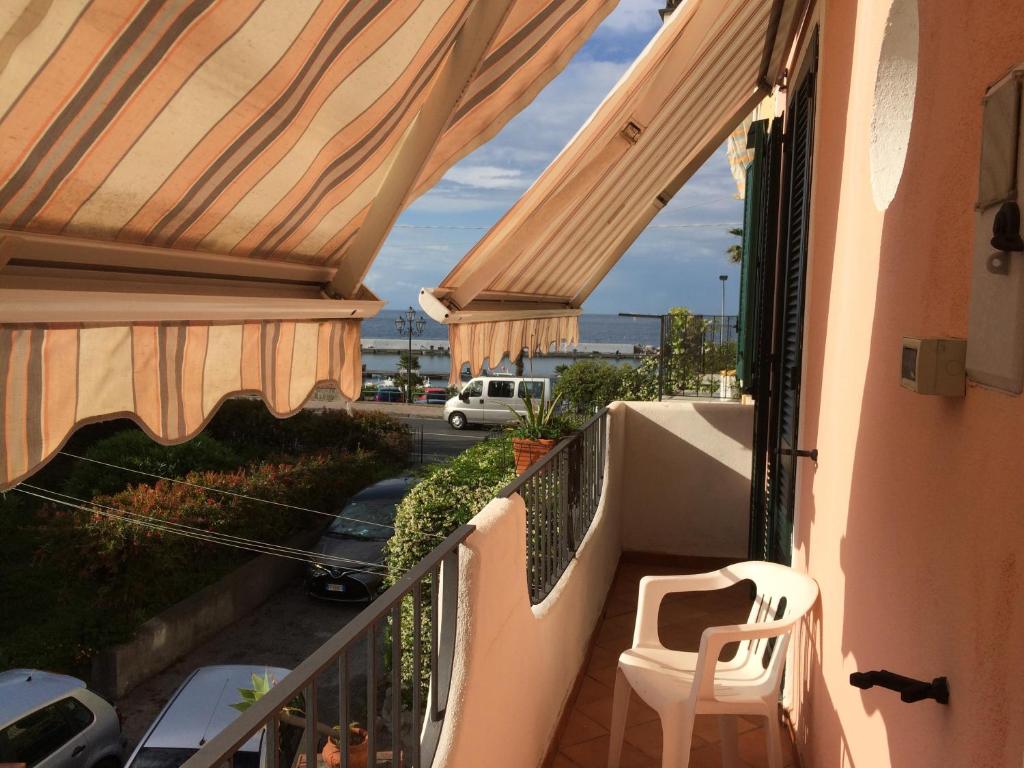 a balcony with a chair and a view of a street at LA CASETTA DI ERIKA in Lacco Ameno