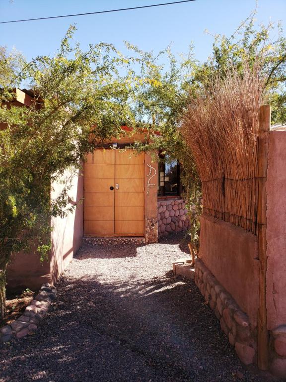 a garage with a wooden door in a yard at Lodge Don Felix in San Pedro de Atacama