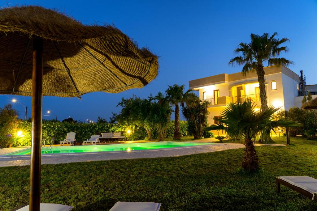 a villa with a swimming pool at night at Aia Grande in Uggiano la Chiesa