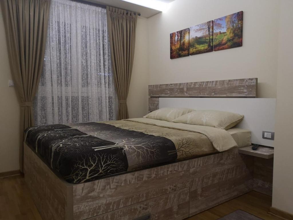 ズラティボールにあるApartman Maximus Zlatiborのベッドルーム1室(ベッド1台付)、窓(カーテン付)