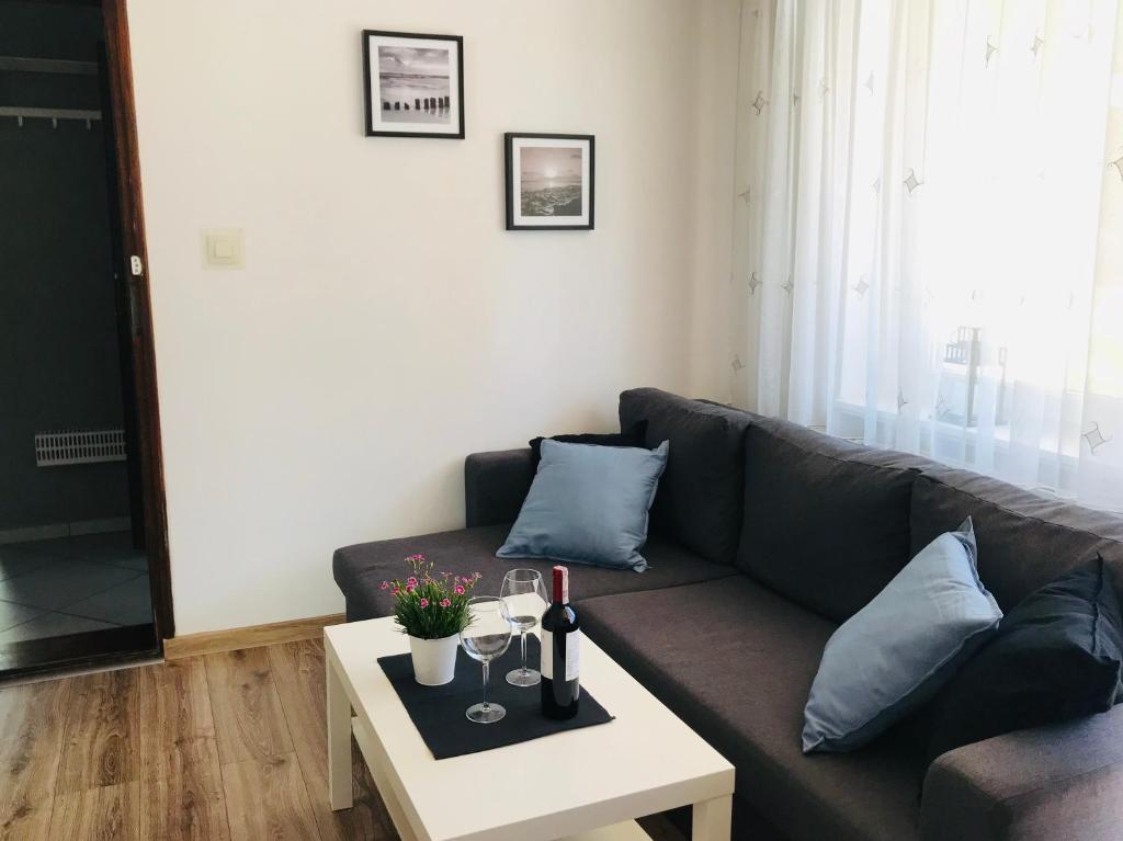 uma sala de estar com um sofá e uma mesa em Pokoje i Apartamenty 200 m do plaży em Karwia