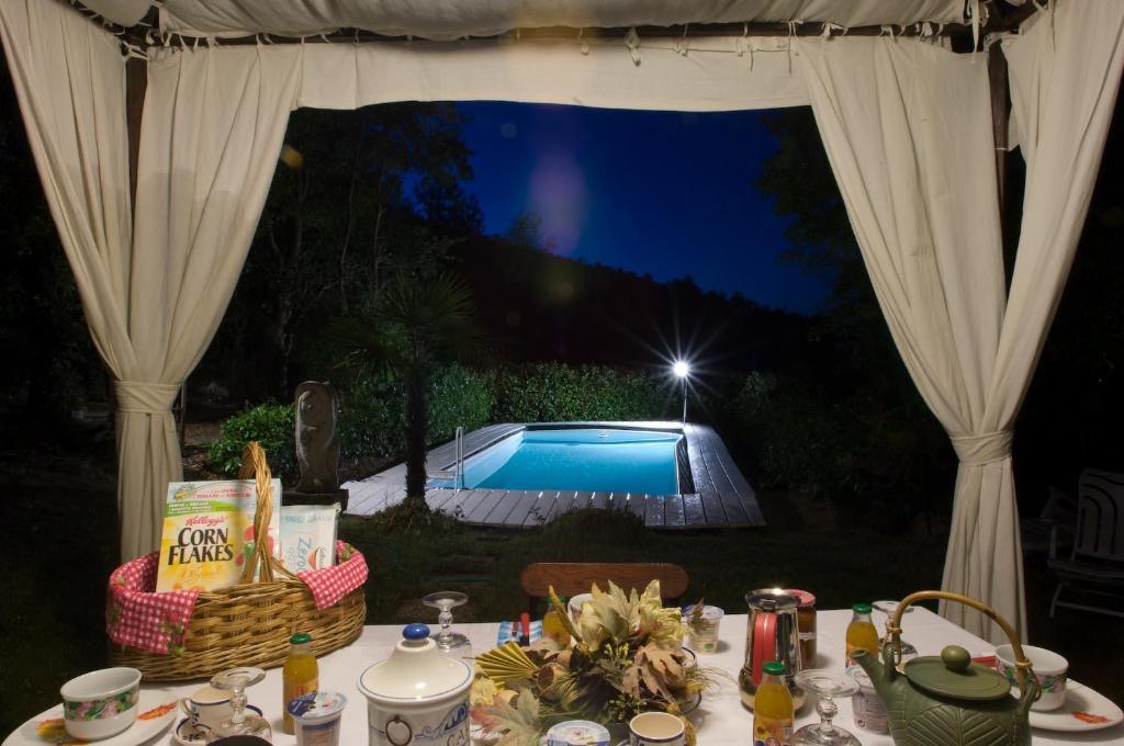 una mesa de comedor con vistas a la piscina por la noche en Prà de Mandè, en Viano
