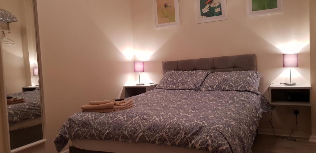 een slaapkamer met een bed met twee lampen aan de muur bij Grant Rooms in Derry Londonderry