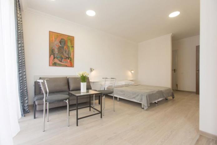 ein Schlafzimmer mit einem Bett und einem Tisch und Stühlen in der Unterkunft Marjanishvili Studios in Tbilisi City
