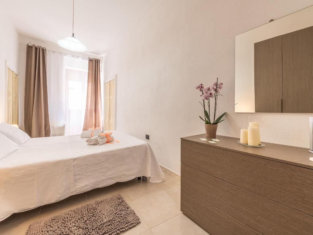 a bedroom with a bed and a dresser with a mirror at Appartamento L'arcobaleno in Cagliari