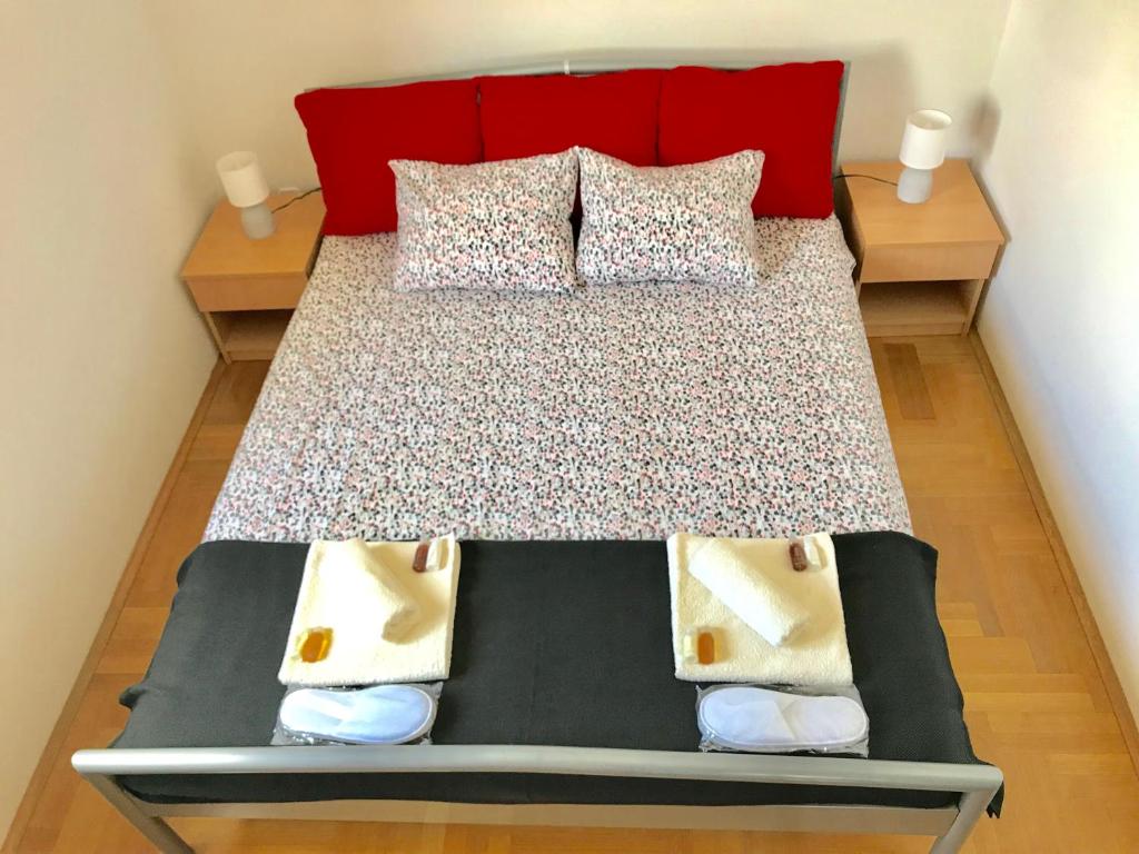 sypialnia z łóżkiem z czerwonym zagłówkiem i poduszkami w obiekcie Apartment Pepa Starigrad Paklenica w mieście Starigrad-Paklenica