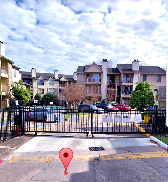 a gate with a red marker in a parking lot at Cozy Condo in Houston