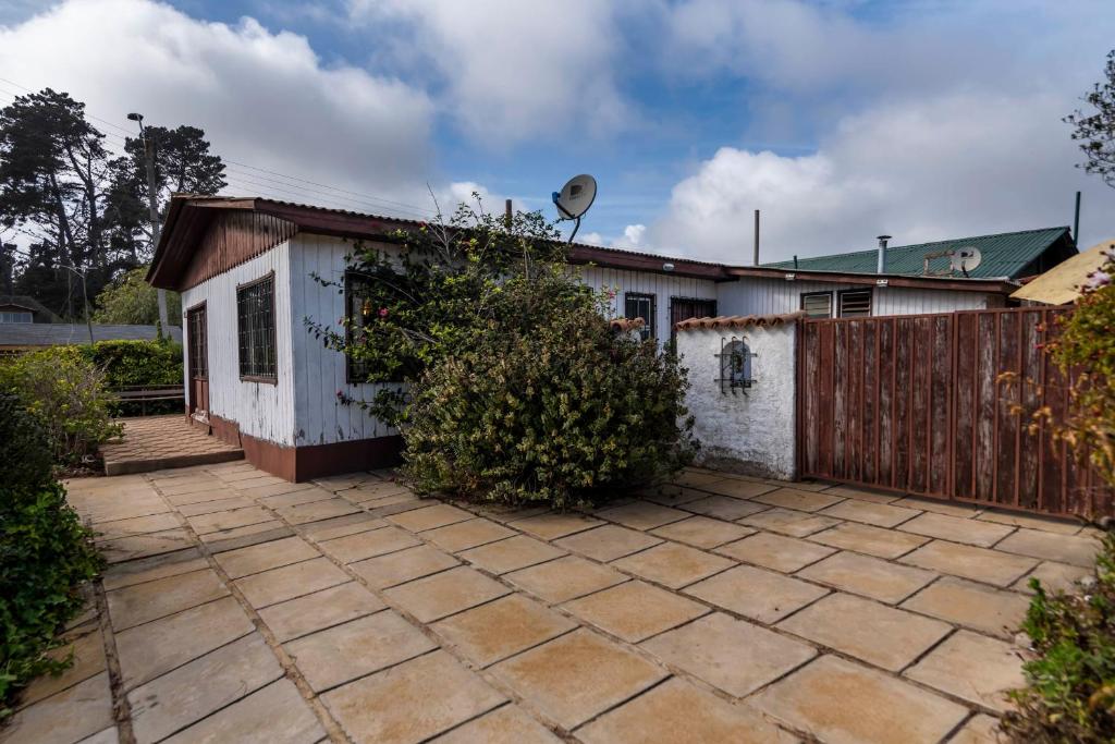 a small white house with a wooden fence at La Casa del Tata, El Quisco in El Quisco