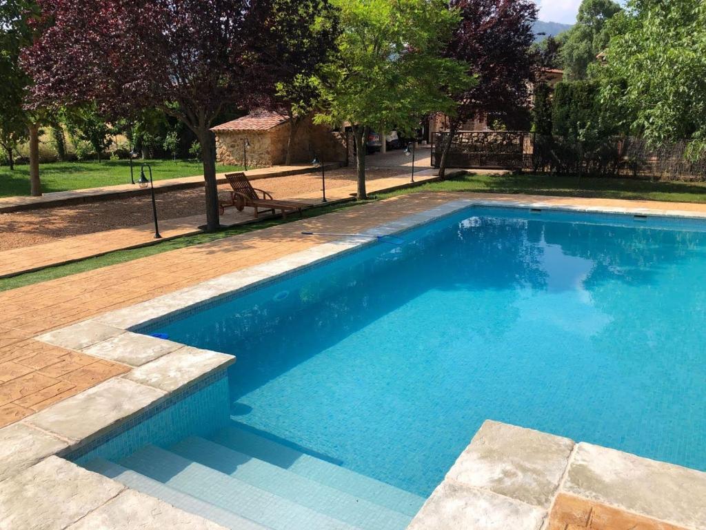 - une piscine d'eau bleue dans la cour dans l'établissement Casas Rurales Majana, à Riópar