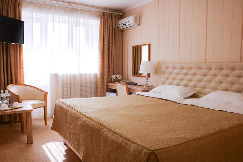 a bedroom with a large bed with a large window at Gavan Hotel in Vladivostok