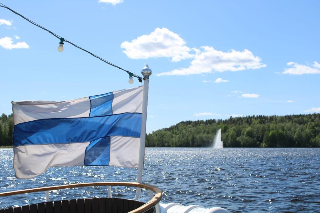 a flag on the bow of a boat on a lake at Soolo 7th floor lake view in Jyväskylä