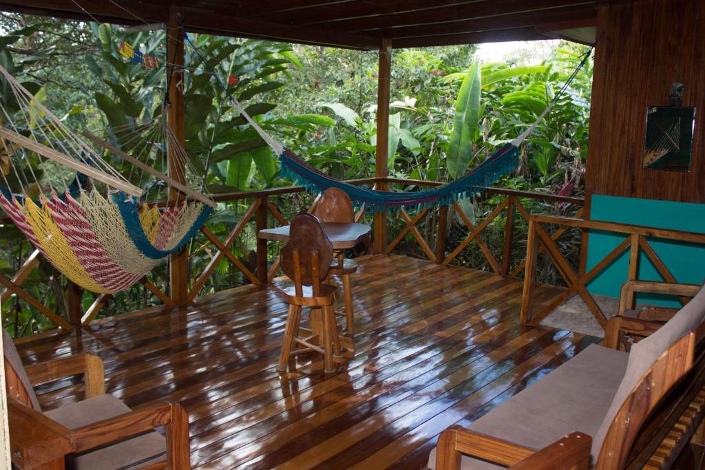 a porch with a hammock and a table and chairs at CasitaCecropia Rental in Drake