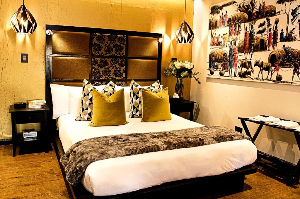 una habitación de hotel con una cama grande con almohadas amarillas en Kgarebana Boutique Guesthouse, en Tweefontein